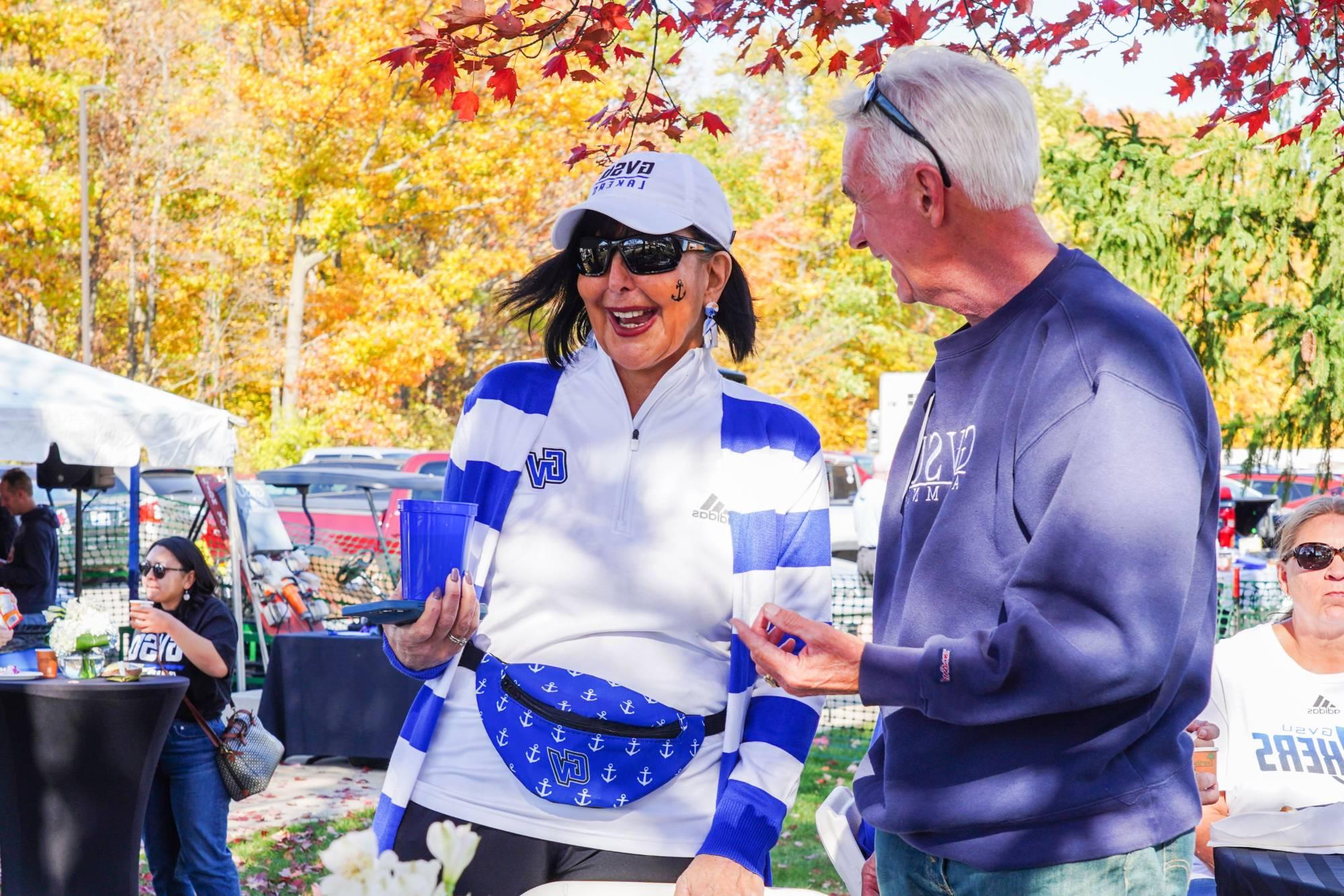 Alum laughing with President Mantella at the Alumni Tailgate.